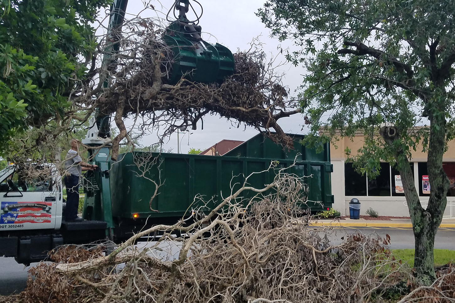 A truck is being used for storm clean up service to remove a tree.